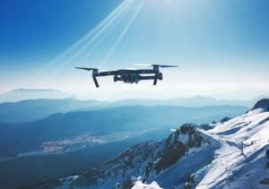 DJI drone with camera flying over snowy mountain peaks for follow me action sports